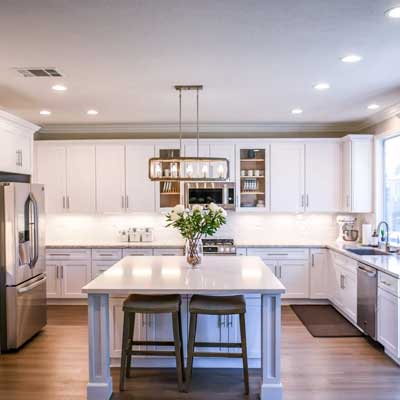 Kitchen-Installations-by-Grimsby-Plastering-Services A modern white kitchen with breakfast bar and wooden floor