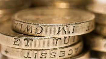 A stack of pound coins on a white background