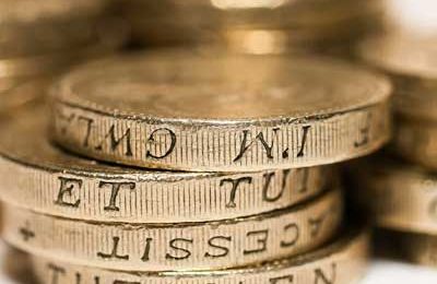 A stack of pound coins on a white background