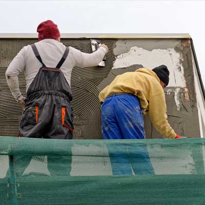 rendering-services-in-Grimsby-with-Grimsby-Plastering-Services Two plasterers rendering a wall